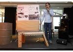 Fotografie - Aktion Sondermöbel - Veranstaltung - vor einer Infowand und einem Sitzmöbel-Modell am Mikrofon Franz Zünkler