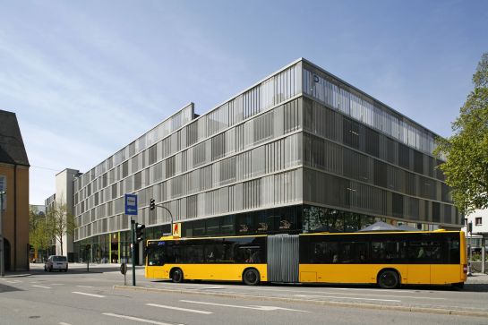 Fotografie: Gelber Bus vor dem Dachauplatz-Parkhaus