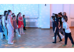 Kinder stehen in der Disco und singen in zwei Gruppen mit- bzw. gegeneinander an