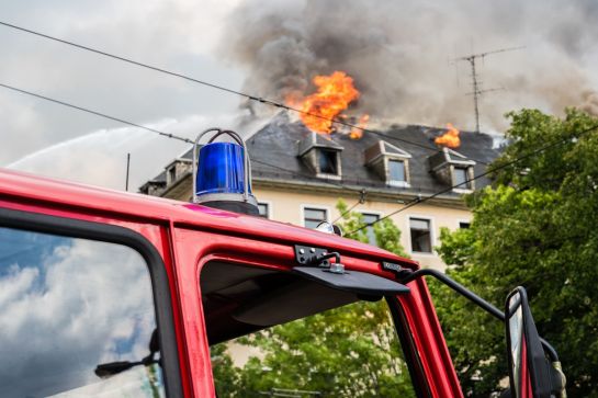 Symbolbild - Feuerwehrauto vor brennendem Haus