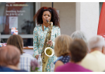 Fotografie: Eine Frau spielt auf einem Saxofon.