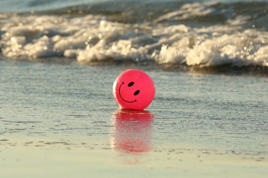 Fotografie – roter Smiley-Luftballon am Strand