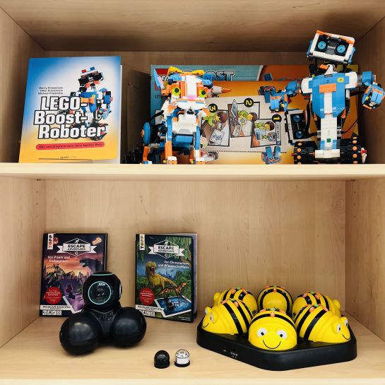 LEGO Roboter und andere programmierbare Roboter in einem Schrank.