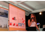 Aktion Sondermöbel - Foto einer Veranstaltung - vor einer Infowand am Mikrofon Larissa Berghofer