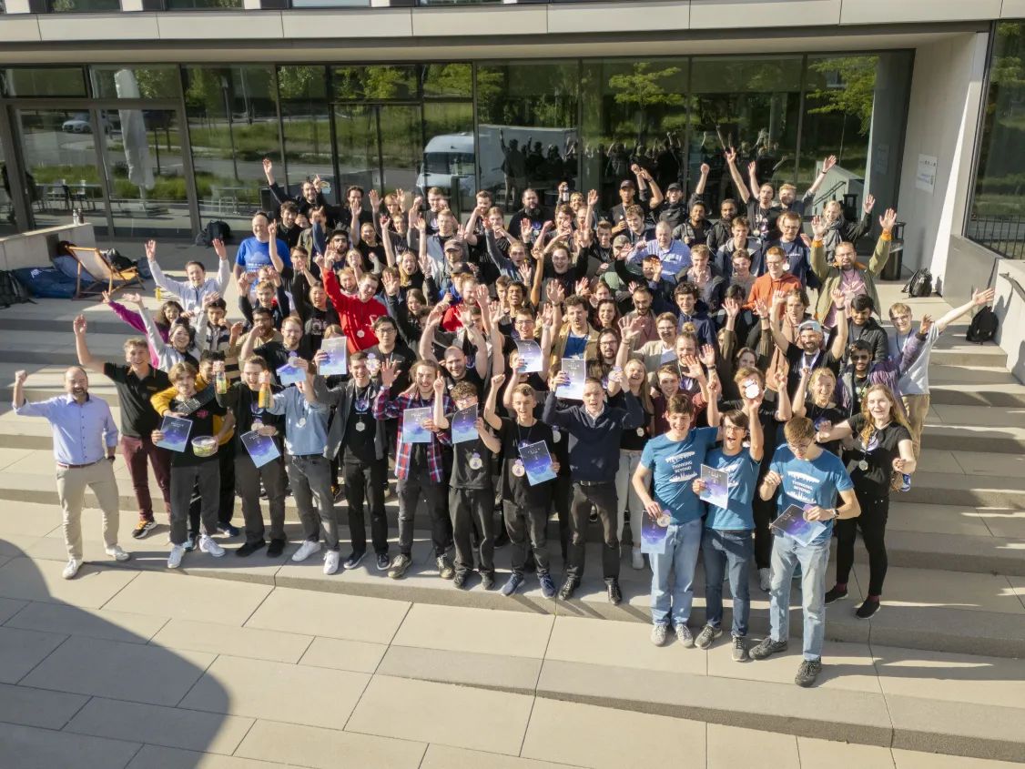 Das Foto wurde aus der Vogelperspektive geschossen und lässt eine große Gruppe erkennen, die vor der TechBase die Hände in die Luft werfen.