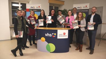 Fotografie: Dr. Ute Eiling-Hütig, Präsidentin des Bayerischen Volkshochschulverbandes (bvv) und MdL (5. v. l.), und die bvv-Vorstände, Dr. Christian Hörmann (3. v. r.) und Dr. Regine Sgodda (4. v. r.), freuten sich mit Bildungsreferentin Dr. Sabine Kellner-Mayrhofer (5. v. r.) und Nina Dollinger-Krome, Leiterin des Amtes für Weiterbildung und der Volkshochschule (4. v. l.), mit vhs-Mitarbeitenden über das druckfrische Programm.