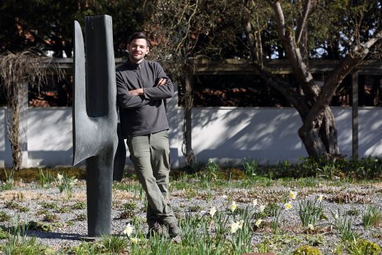 Fotografie: Matthias Peter lehnt an einer Statue und steht zwischen blühenden Narzissen.