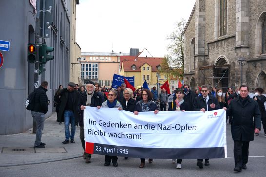 Viele Menschen gehen mit einem Banner auf einer Straße in Regensburg
