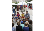 Fotografie: Ein Mann erklärt Kindern einen Stein.