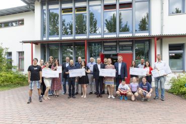 Fotografie: Bürgermeister Ludwig Artinger (Mitte) und der Leiter des Amtes für Schulen Stephan Weinmann (6. v. l.) verliehen die diesjährigen Öko-Schulpreise.