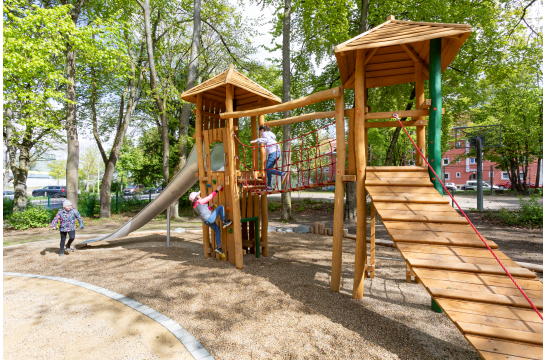 Fotografie: Drei Kinder erobern den sanierten Spielplatz an der Safferlingstraße.