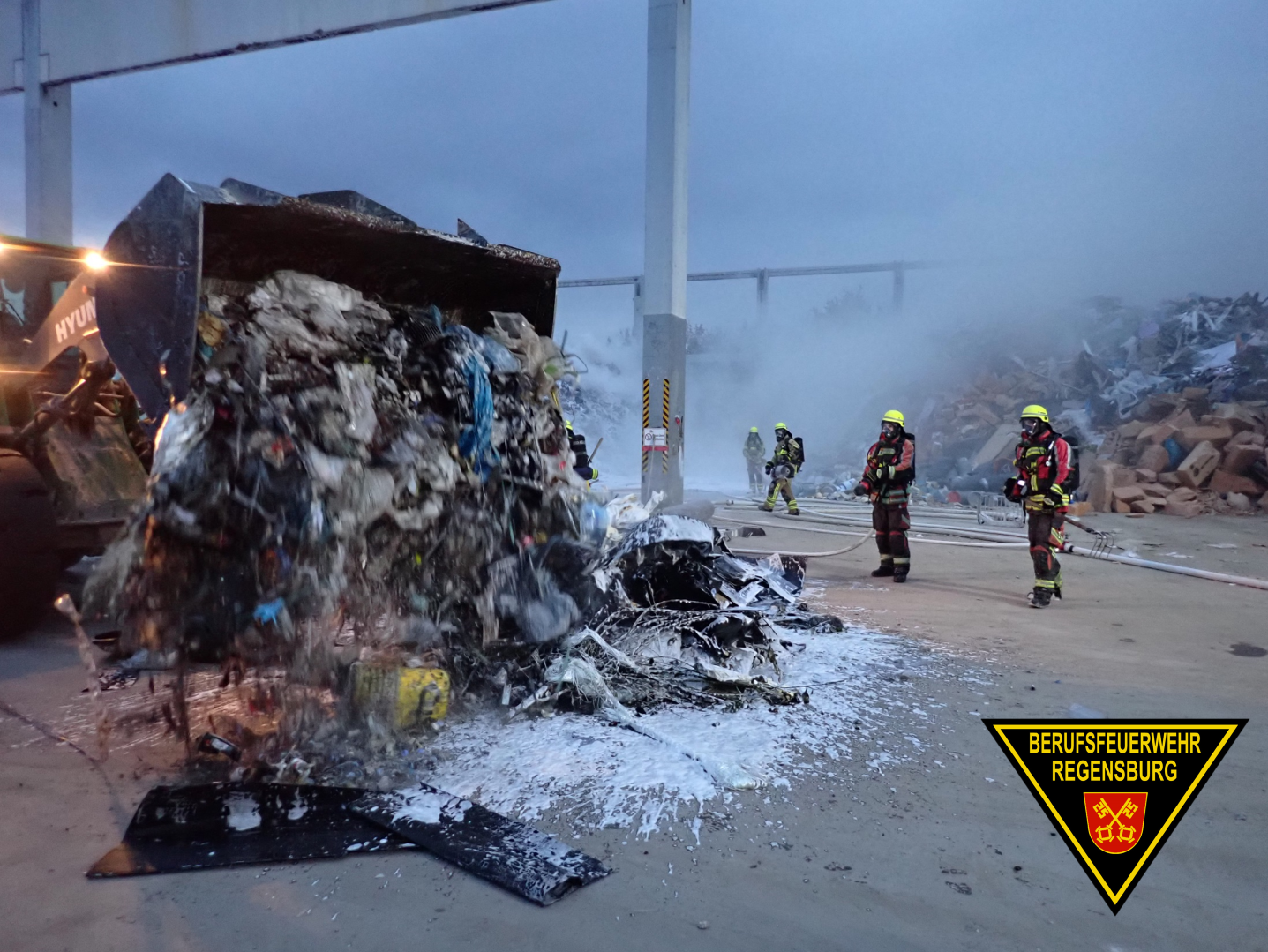 Feuerwehrleute löschen brennenden Müllhaufen