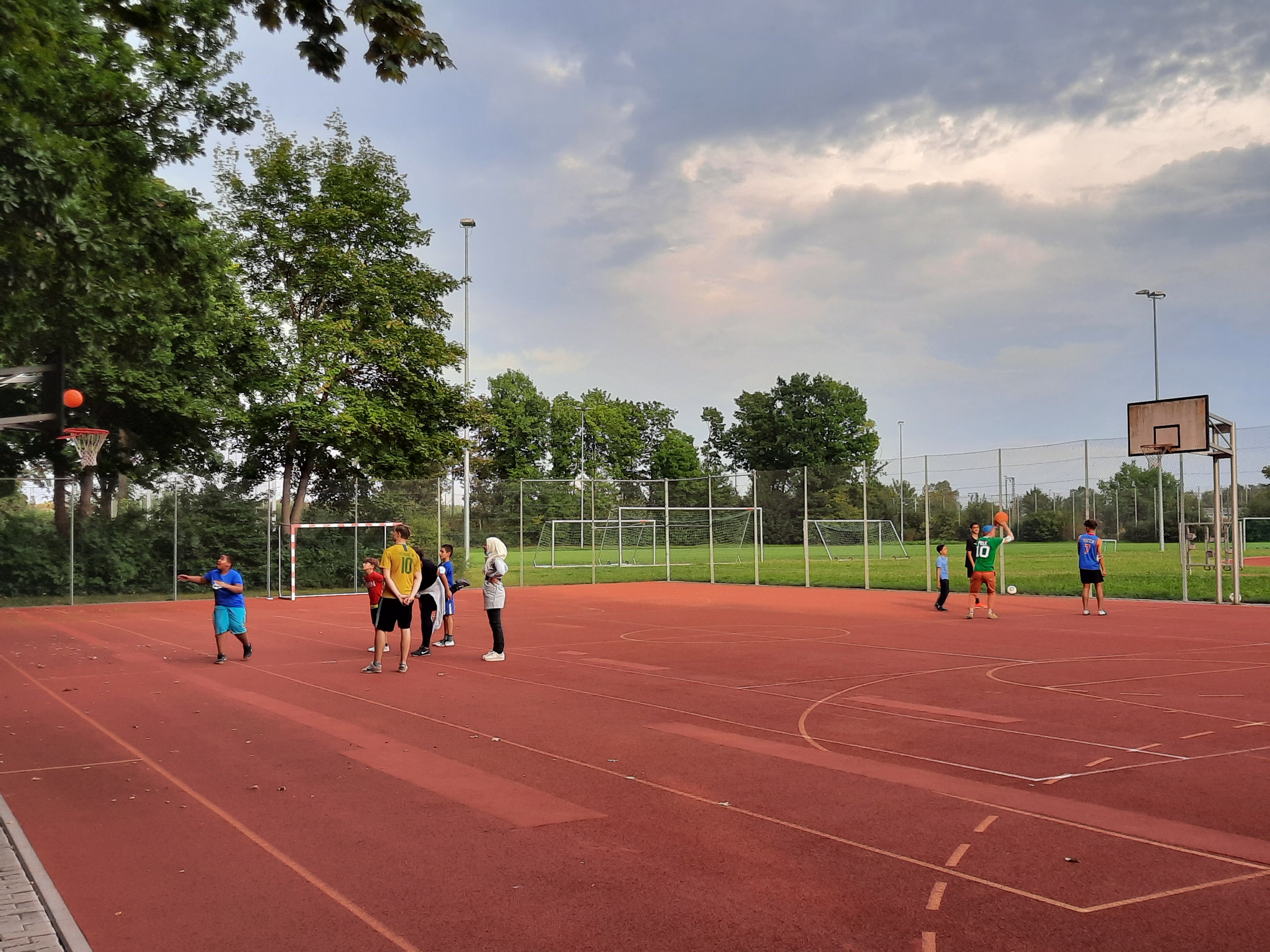 Es sind mehrere Personen auf dem Sportplatz zu sehen.