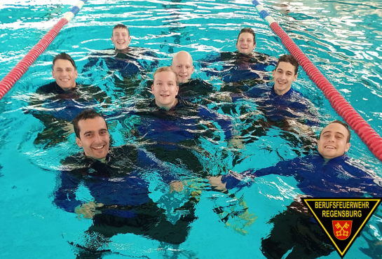 Fotografie: Gruppenbild der Brandmeisteranwärter mit Neoprenanzug im Schwimmbecken.