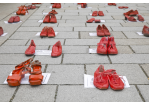 Fotografie: Rote Schuhe stehen in Reihen auf der Steinernen Brücke.