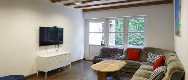Fotografie - Gruppenraum mit Couchen und Fernseher