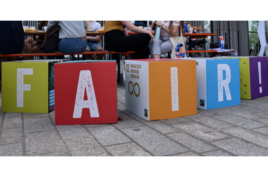 Fotografie: Vier bunte Würfel bilden das Wort „Fair“.