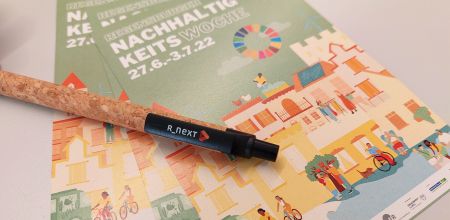 Stift mit R_NEXT Logo auf Flyer der Nachhaltigkeitswoche 2022