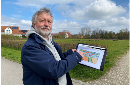 Fotografie: Stadtheimatpfleger Dr. Gerhard Waldherr zeigt vor dem Gelände der Villa Rustica die Lage der Gebäude. 