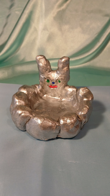 Kunstwerk rundes Metallstück mit Tierkopf