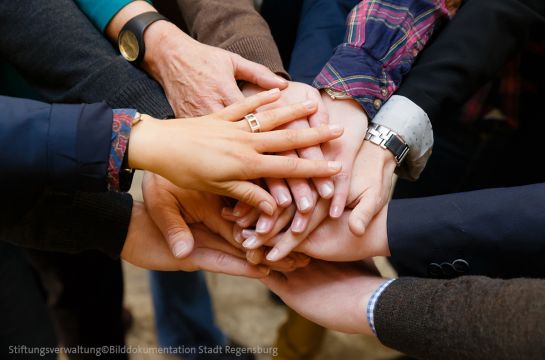 Themenbild Städtische Stiftungen - Fotografie - mehrere Personen legen ihre Hände übereinander