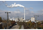 Fotografie: Blick über Gleise auf die ehemalige Zuckerfabrik mit qualmendem Schornstein