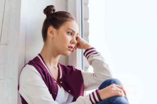 Fotografie: Jugendliche sitzt am Fenster