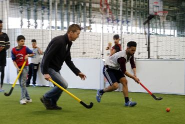 Fotografie: Männer spielen Hockey.