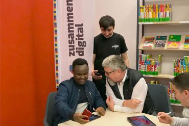 Fotografie: Ein junger Mann berät einen älteren Herren.