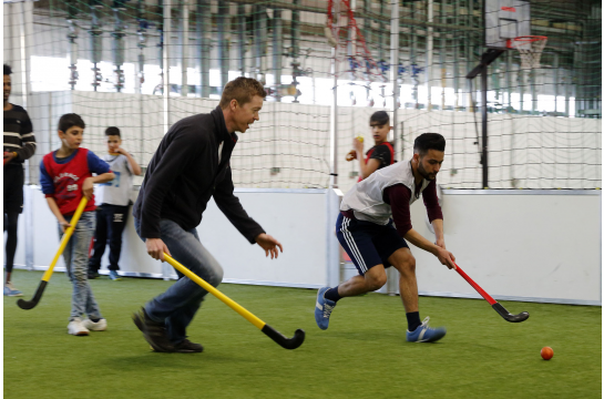 Fotografie: Männer spielen Hockey.