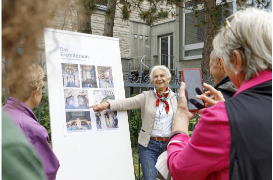 Fotografie: Eine Frau erklärt ein Schild.