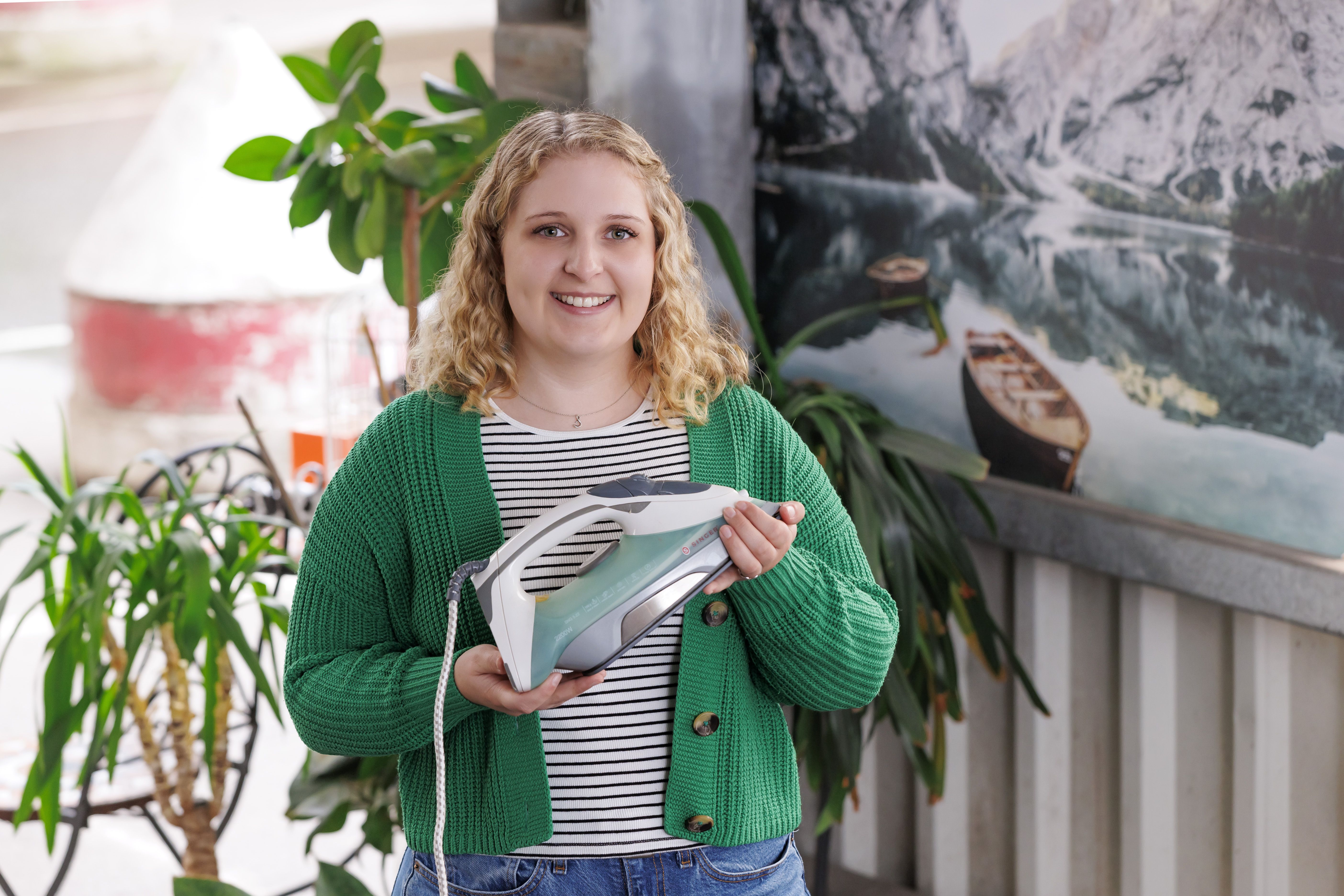 Fotografie: Sabine Obermeier mit einem Dampfbügeleisen in der Hand