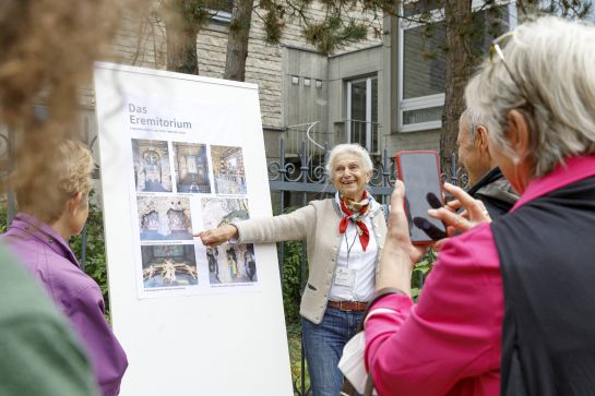 Fotografie: Eine Frau erklärt ein Schild. (C) Bilddokumentation Stadt Regensburg