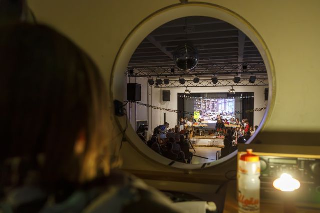 Rundes Fenster in einen Saal mit Bühne