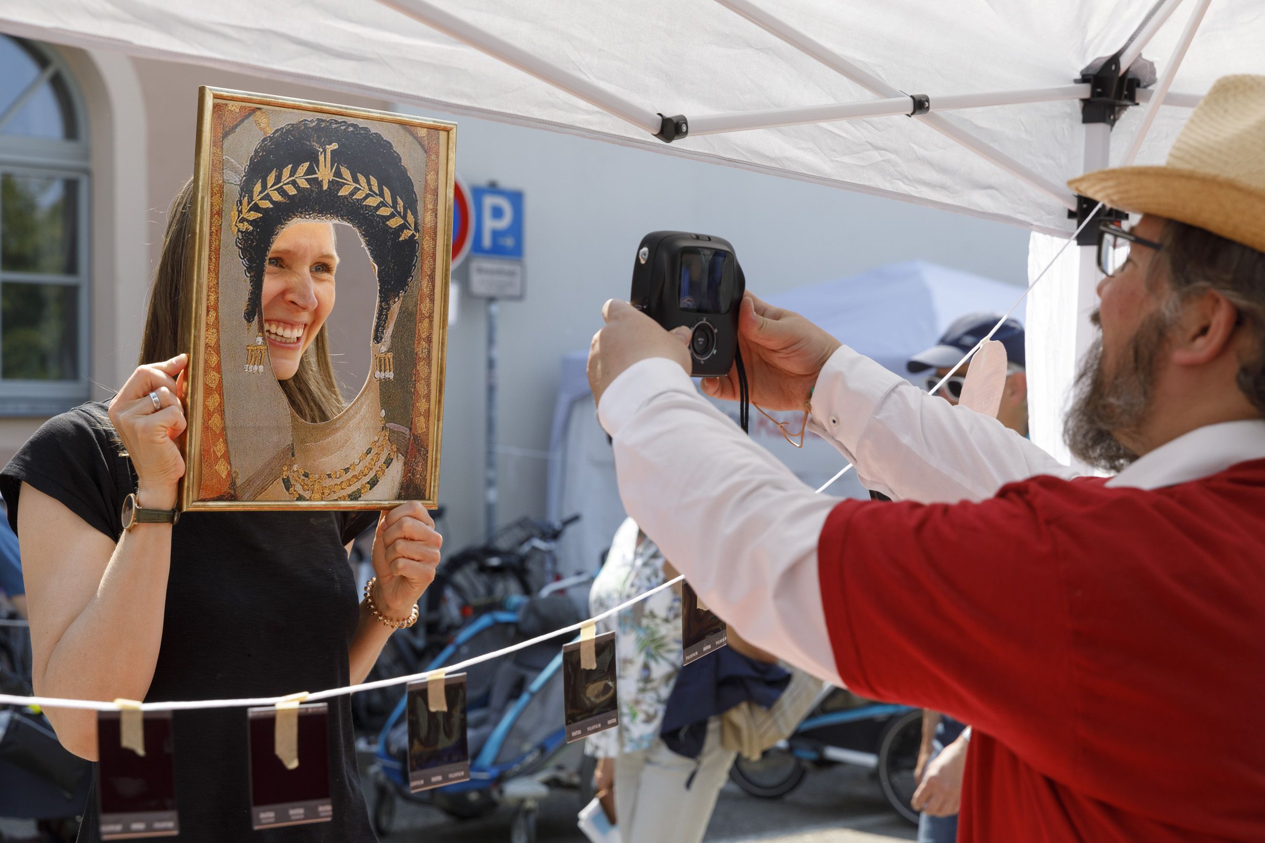 Fotografie: Eine Frau lässt sich hinter einem ausgeschnittenem Bilderrahmen fotografieren.
