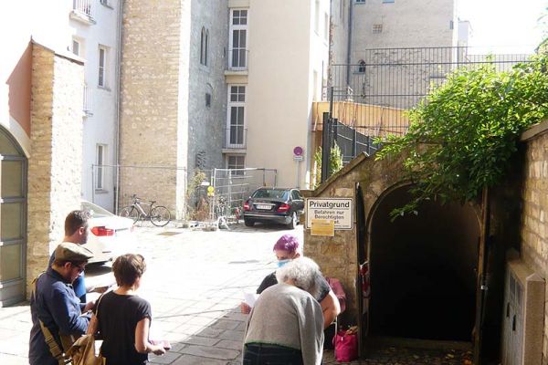 Fotografie - eine Gruppe Menschen steht in der Regensburger Altstadt bei einem Rundgang