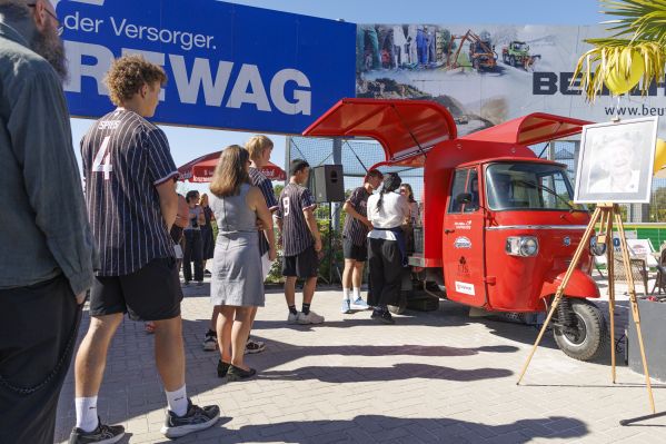 Fotografie: Menschen stehen Schlange vor der roten Eis-Ape.