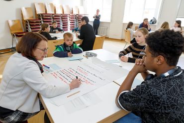 Fotografie - inhaltliche Arbeit und Gespräch an Tischen mit Plakaten – Kinder mit Oberbürgermeisterin Gertrud Maltz-Schwarzfischer, Bildungsreferentin Dr. Sabine Kellner-Mayrhofer und Amtsleiterin Annerose Raith