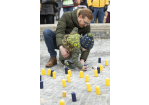 Fotografie: Ein kleiner Junge und ein Mann stellen eine Kerze in den Brunnen am Bismarckplatz.