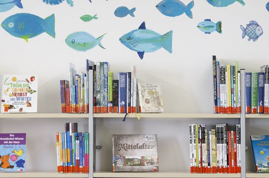 Forografie - Über den Kinderbücher-Regalen in der Stadtteilbücherei Ost schwimmen blaue Fische an der Wand. (C) Bilddokumentation Stadt Regensburg