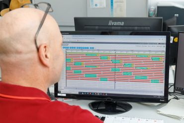Fotografie: Ein Mitarbeiter sitzt vor dem Monitor, der die Abläufe an den Ampelanlagen anzeigt.