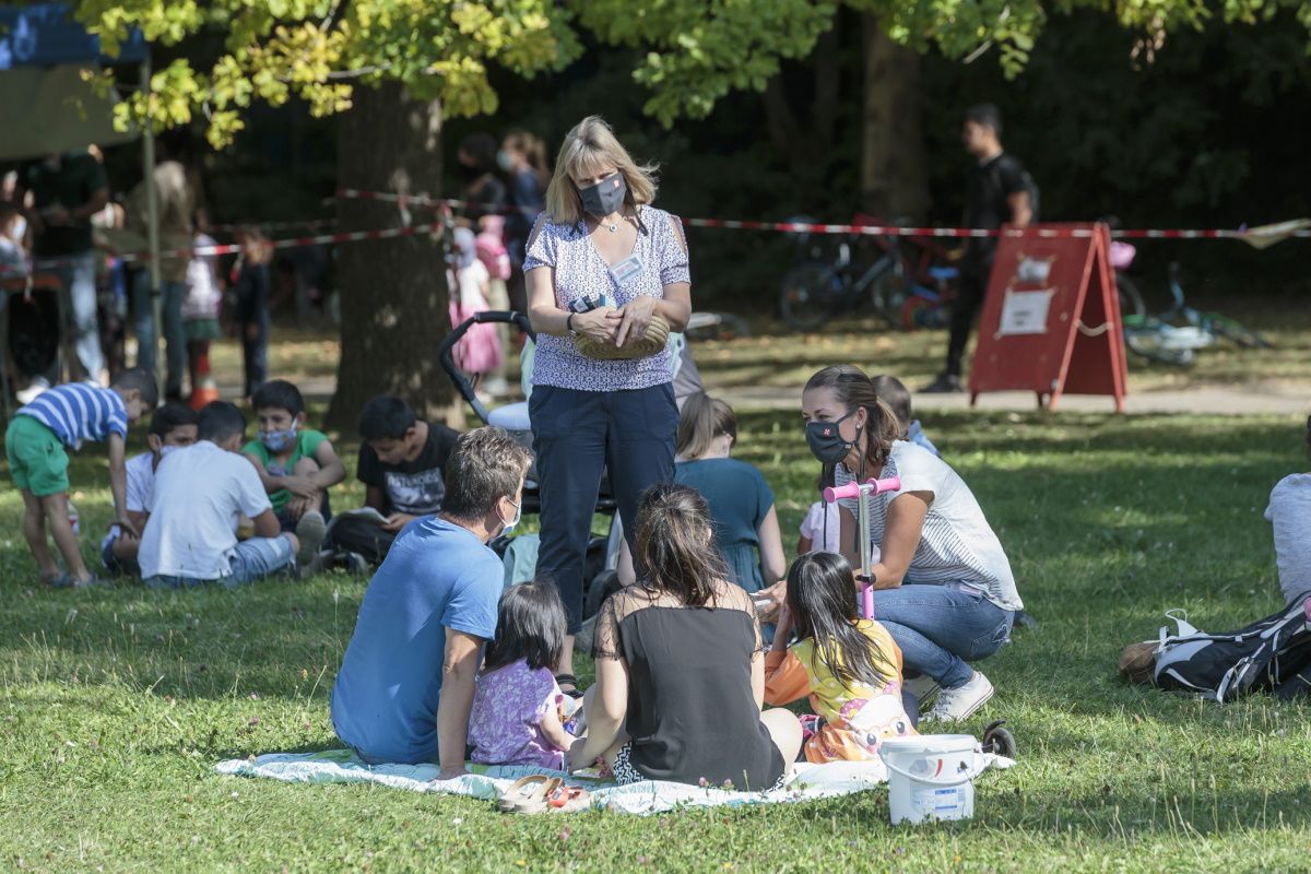Fotografie - Personen sitzen auf einer Decke im Gras