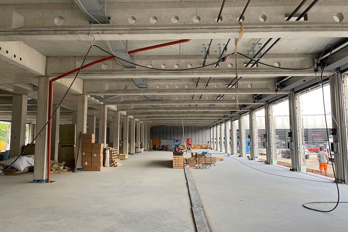 Fotografie - Blick in die Fahrzeughalle (West Richtung Ost). Die graue Wand wird später entfernt und der Lückenschluss zur Fahrzeughalle in Bauteil 3a hergestellt.