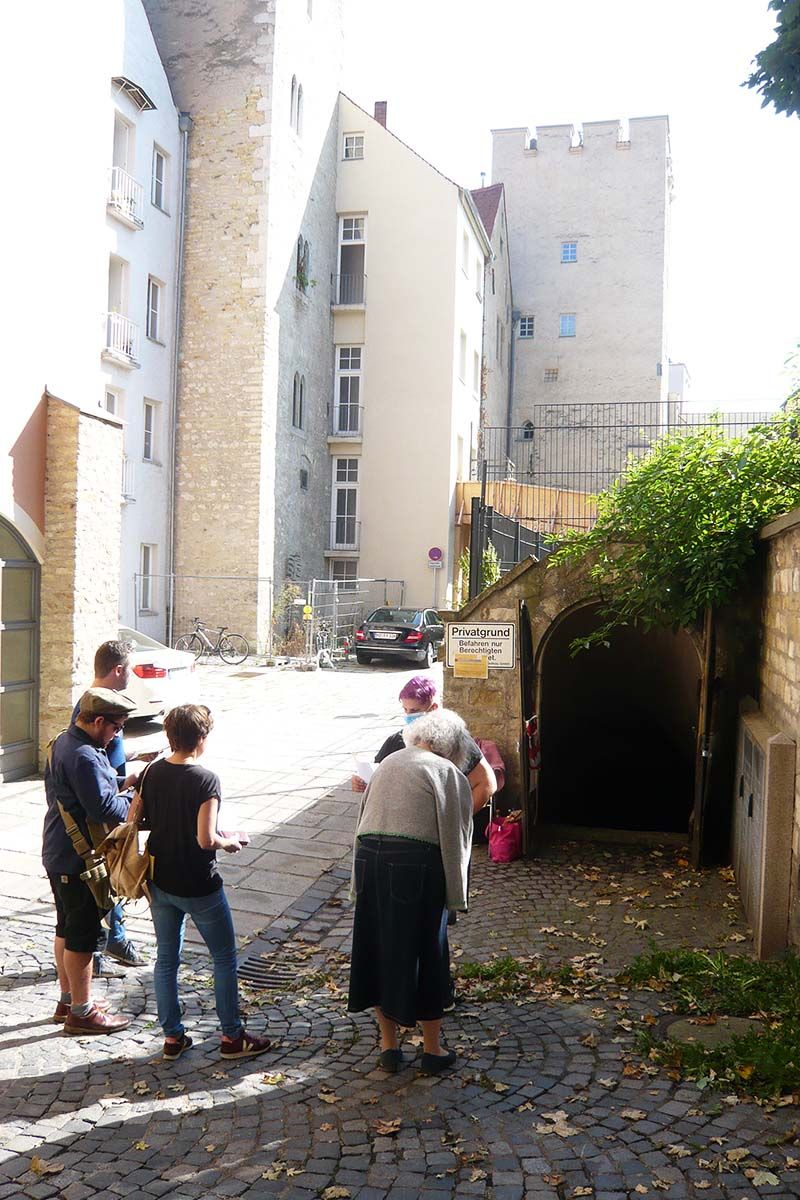 Fotografie - eine Gruppe Menschen steht in der Regensburger Altstadt bei einem Rundgang