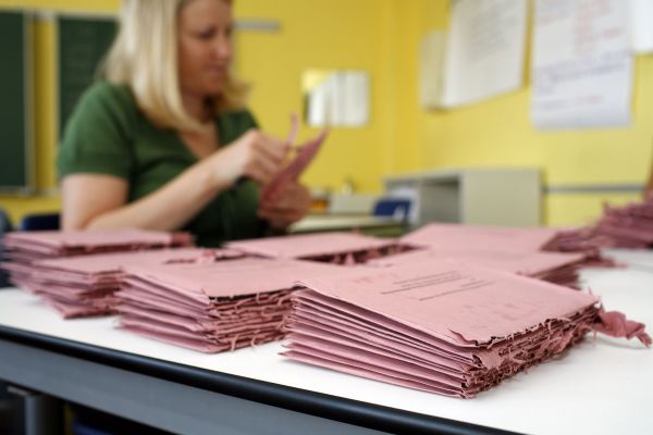 Fotografie: Eine Frau öffnet Wahlbriefe.