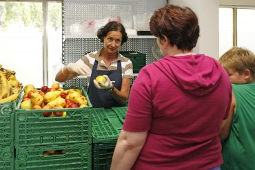 Frau mit Apfel am Marktstand