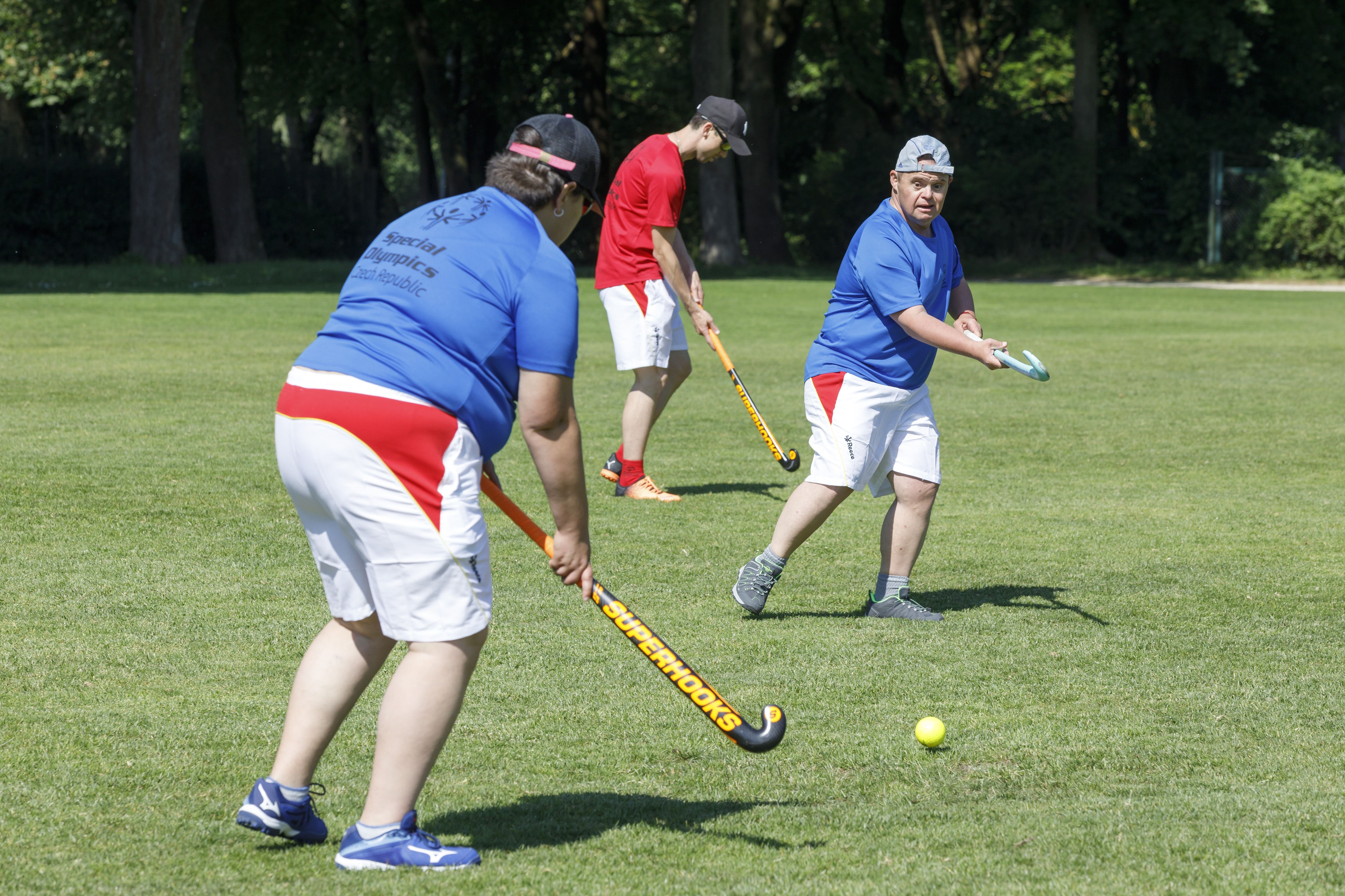 Fotografie: Drei Männer beim Rasenhockey