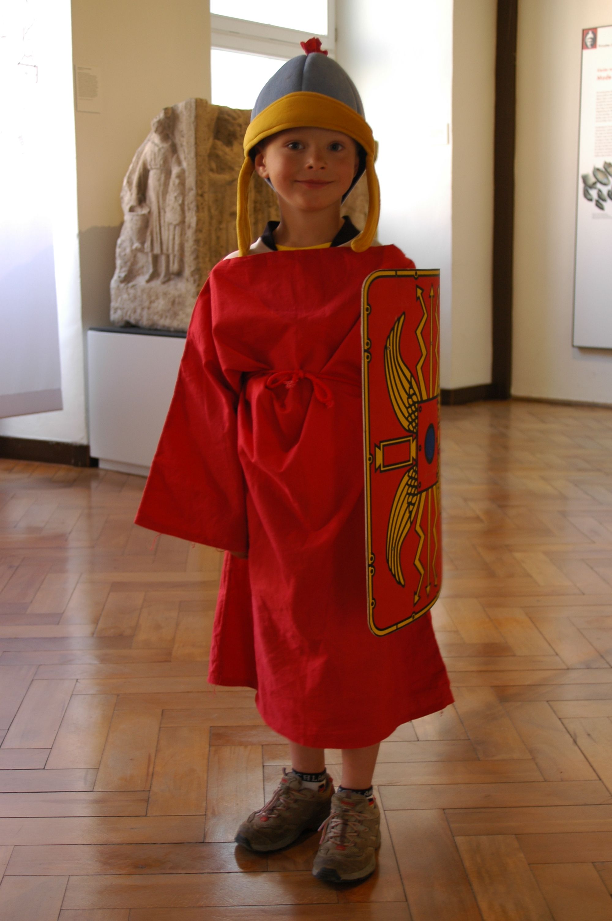 Fotografie – ein kleiner Junge mit Römerhelm, rotem Umhang und Schild