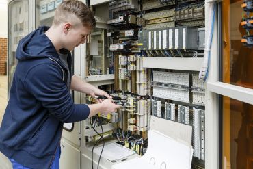 Fotografie -Person arbeitet an einem Schaltschrank