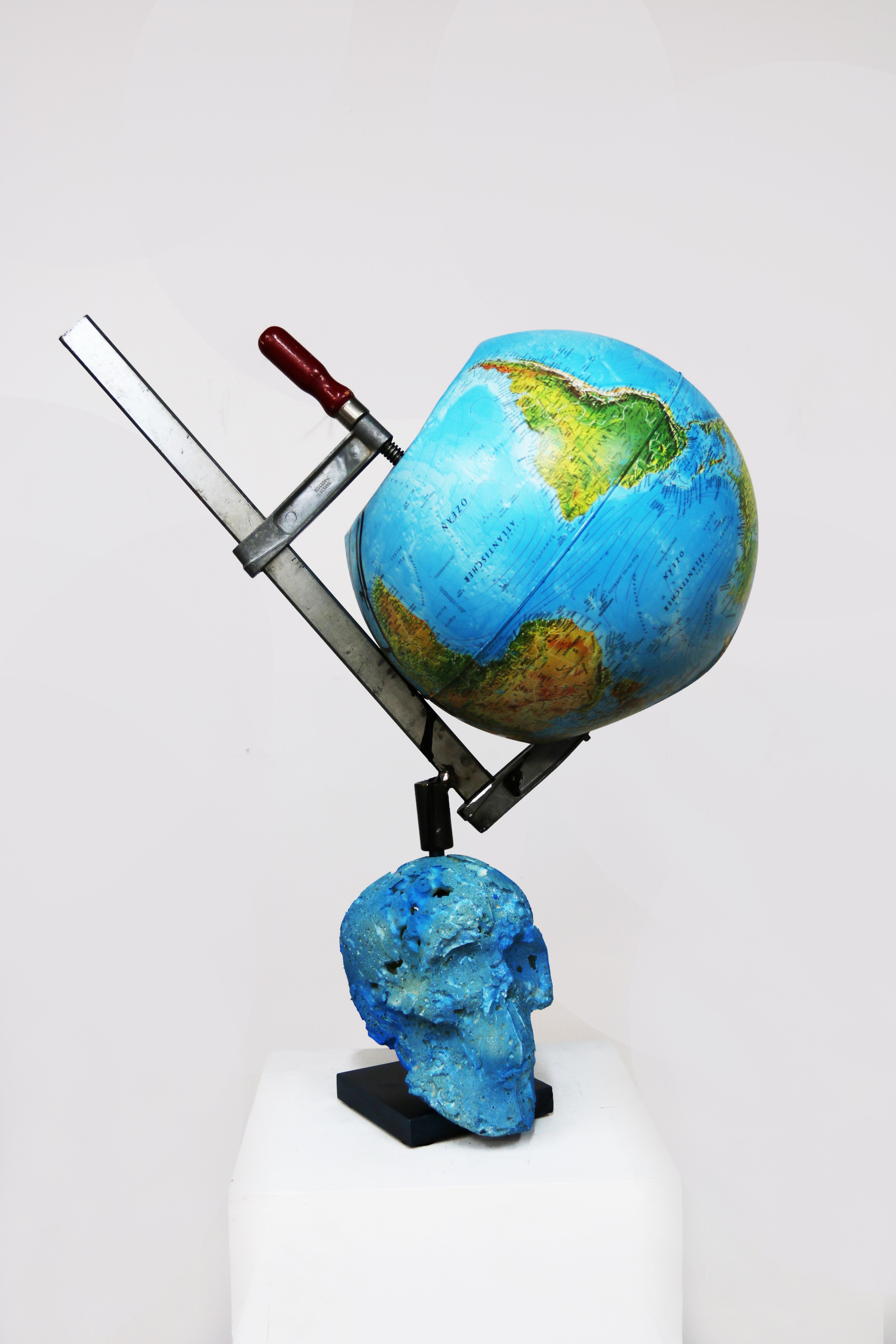 Fotografie – auf einem Gipskopf ist mit einer Schraubzwinge ein Globus fixiert